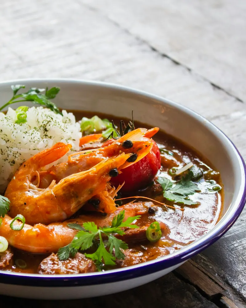 Garnelen-Gumbo mit Reis in einer Schüssel auf einem Holztisch